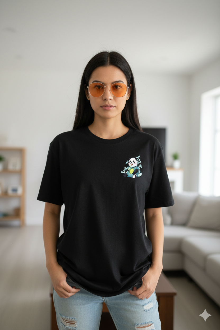 Woman wearing a black t-shirt with a small design, standing in a living room.